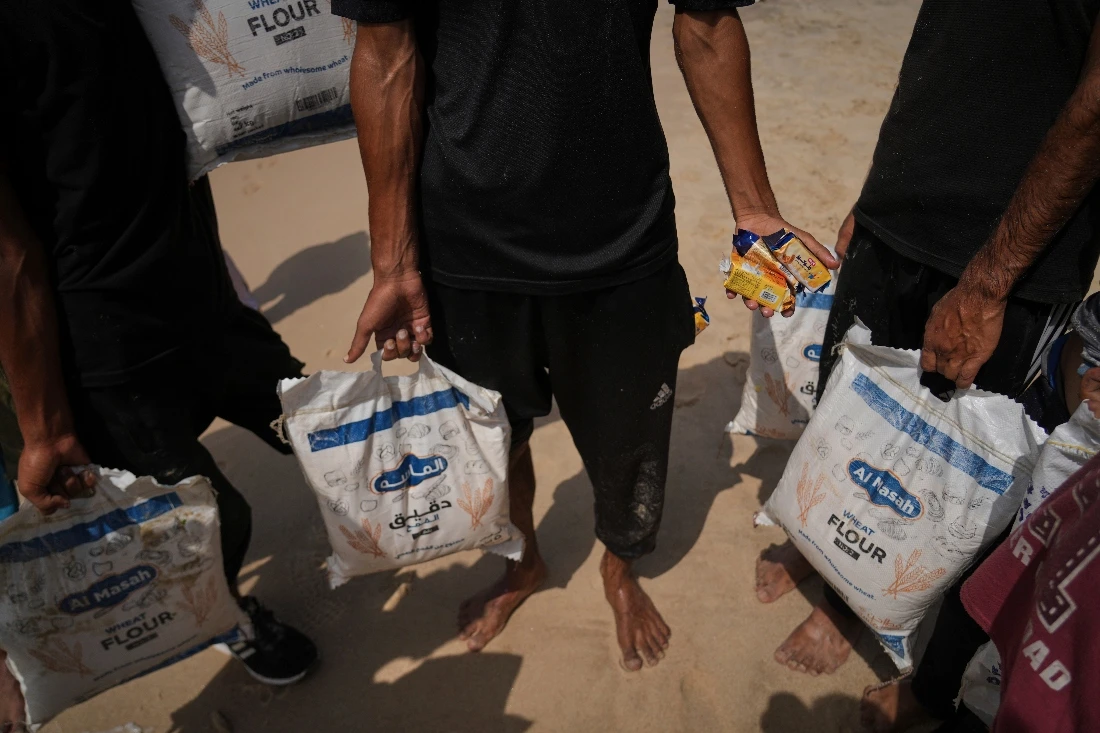 Palestinians collect aid that landed in the Mediterranean Sea after being airdropped over central Gaza. (AP)