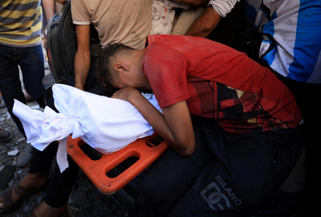 A mourner reacts next to a body during the funeral of Palestinians, who were killed by Israeli fire while trying to receive aid, on Wednesday in Gaza City, July 31, 2025. (Reuters)