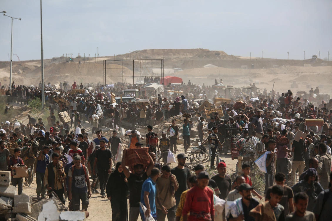 Palestinians carry aid supplies which they received from the US-backed Gaza Humanitarian Foundation, in the central Gaza Strip, July 31, 2025. (Reuters)