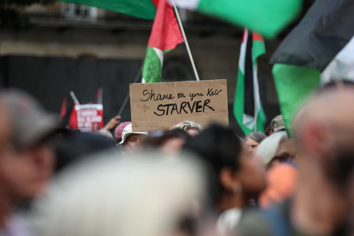 A protester holds a placard reading the message with a play on words on the name of Britain's Prime Minister Keir Starmer. (AFP)