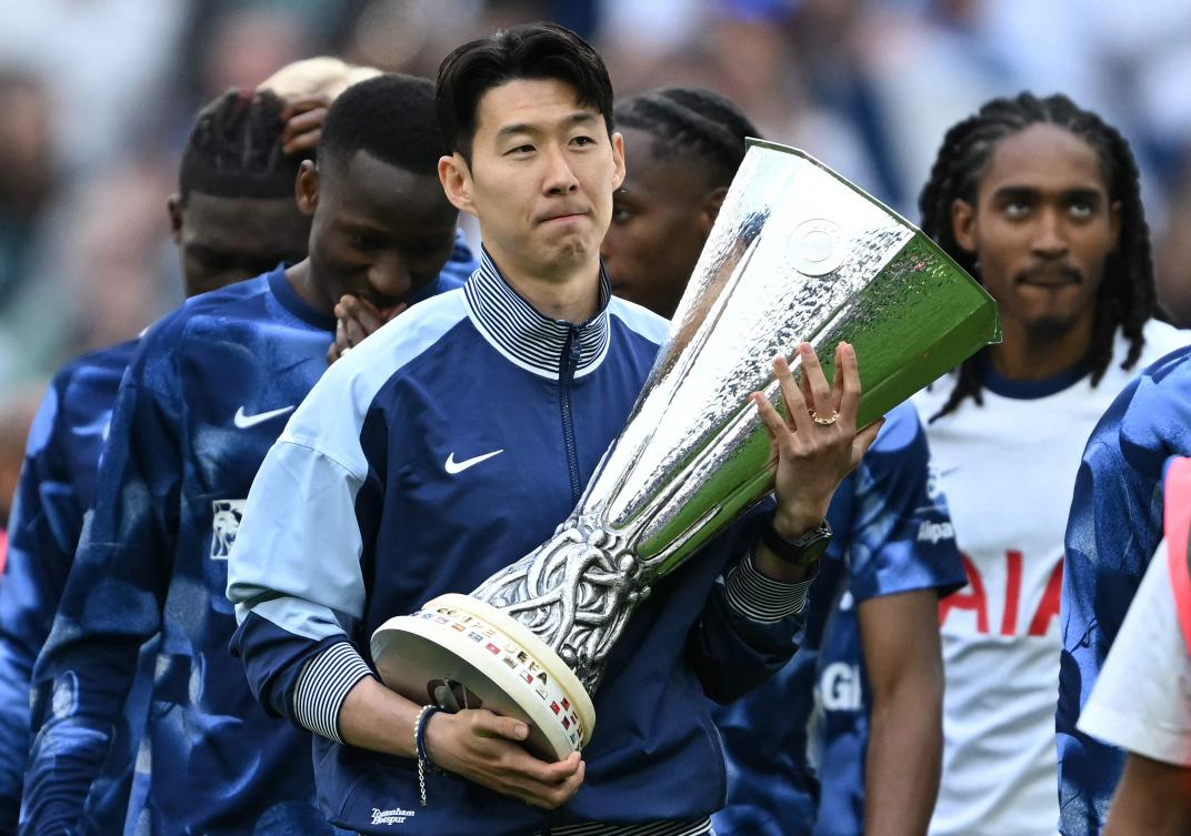Tottenham Hotspur’s South Korean forward Son Heung-Min carries the Europa League trophy, following their mid-week win in the Europa League Final on May 21, 2025. (AFP)