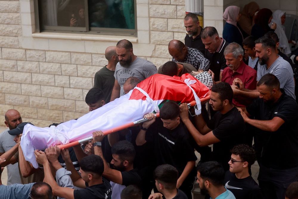 Mourners carry the body of Khamis Ayyad, a Palestinian-American who was killed in an attack by Israeli settlers, during his funeral in Silwad near Ramallah, in West Bank on Aug. 1, 2025. (Reuters)