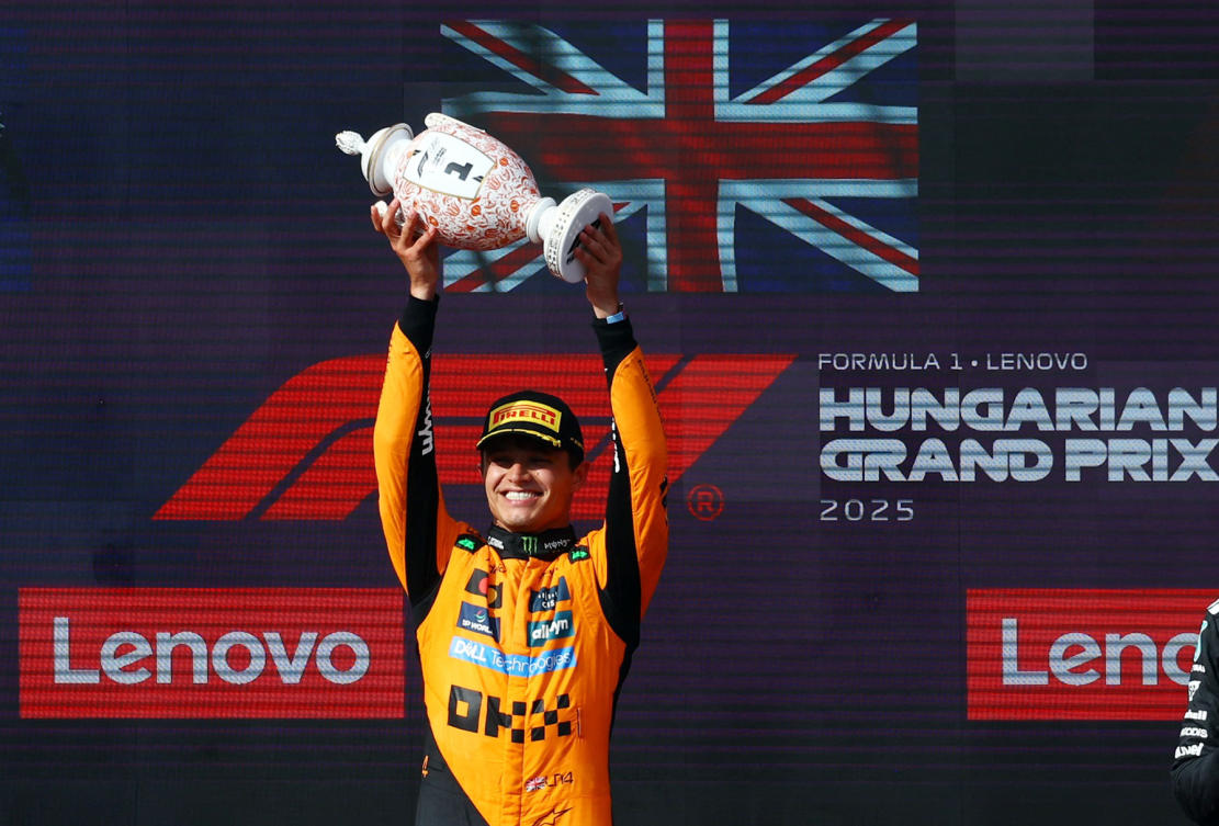 McLaren’s Lando Norris celebrates on the podium with a trophy after winning the Hungarian Grand Prix. (Reuters)