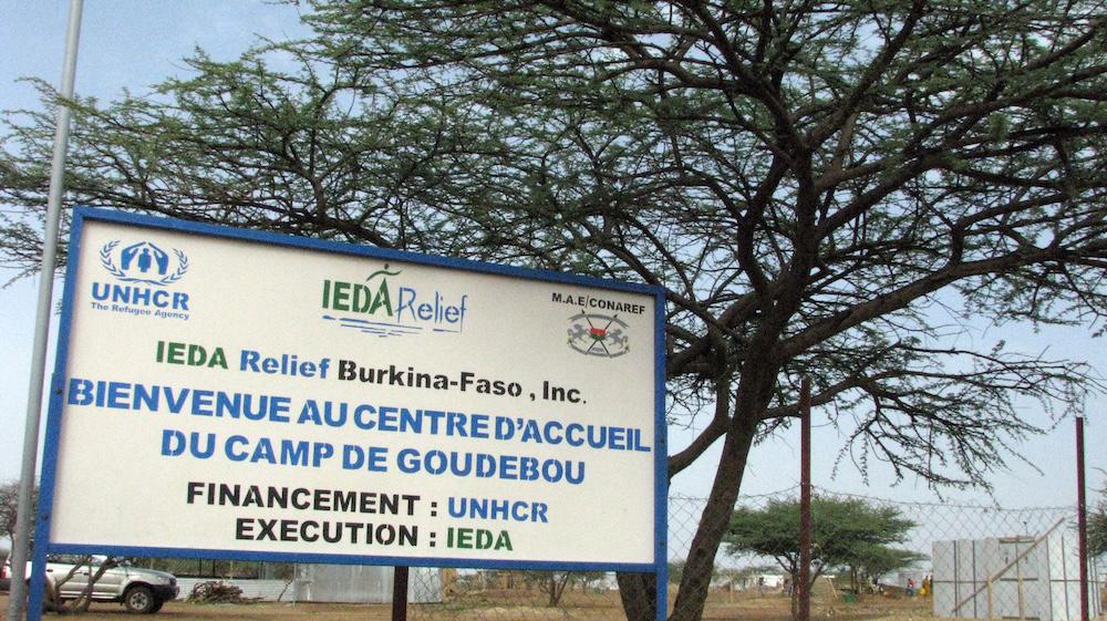 Above, a billboard advertises the entrance of a refugee camp for Malian refugees in Goudebou in Burkina Faso on July 26, 2013. (AFP file photo)