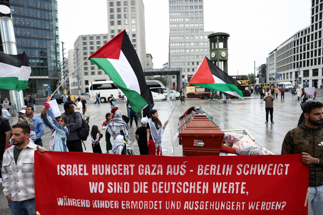 People hold a banner that reads as they protest against Israel and in solidarity with Palestinian children in Gaza, at Potsdamer Platz, in Berlin, Germany, August 3, 2025. (Reuters)