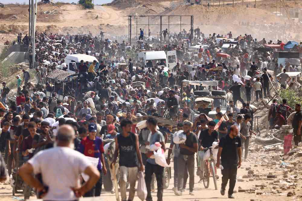 Displaced Palestinians gather to receive aid run by the US and Israeli-backed Gaza Humanitarian Foundation (GHF) at the so-called "Netzarim corridor" in central Gaza. (AFP)