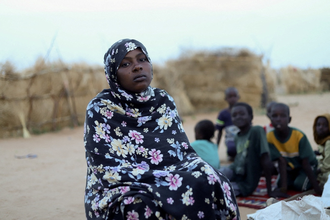 A displaced Sudanese woman and children look on inside a camp shelter in North Darfur, Sudan. (Reuters)