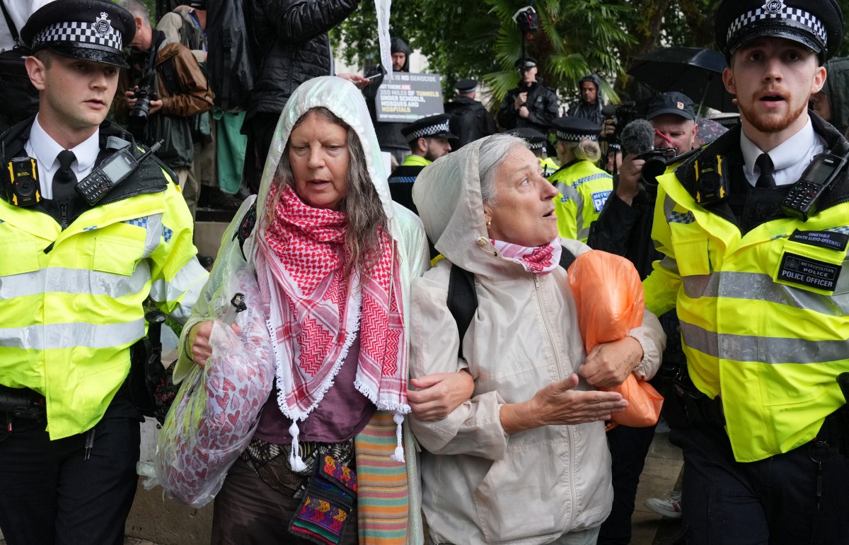 Protesters are escorted away by police officers at a demonstration in support of the proscribed group Palestine Action calling for the recently imposed ban to be lifted, in Parliament Square, central London, on July 19, 2025. (File/AFP)