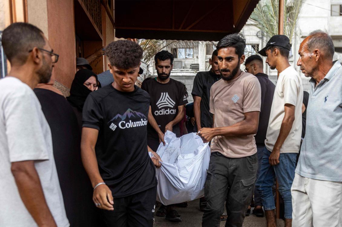 Mourners carry the body of one of the victims killed during overnight Israeli bombardment on a camp sheltering displaced people in the Mawasi area of Khan Yunis, during the funeral at Nasser Medical Complex in Khan Yunis in southern Gaza Strip on August 5, 2025. (AFP)