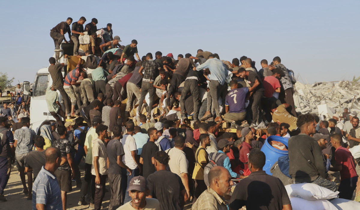 Palestinians ride on a truck loaded with food and humanitarian aid as it moves along the Morag corridor near Rafah, in the southern Gaza Strip, Monday, Aug. 4, 2025. (AP)