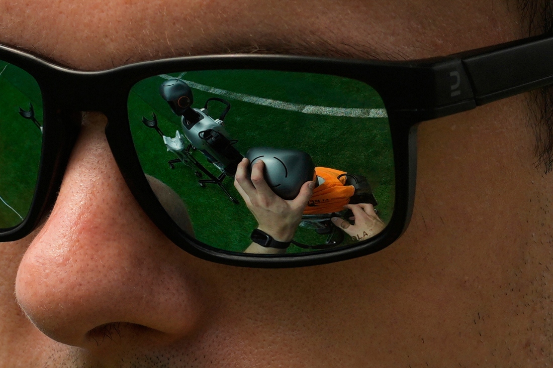 A technician checks a Booster humanoid robot as it reflects on his glasses in Beijing, China. (AP)