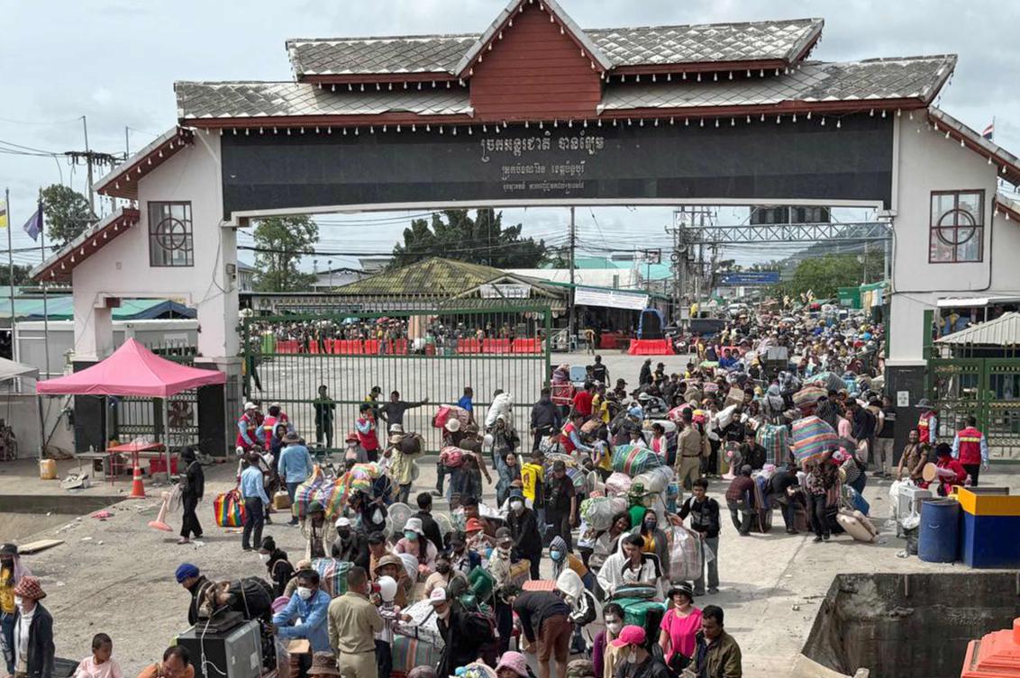 This handout photo taken and released by Cambodia's Ministry of Labour on August 6, 2025 shows Cambodian migrant workers carrying their belongings as they returned from Thailand following border clashes through the Daung International Border Gate in Battambang province. (AFP)