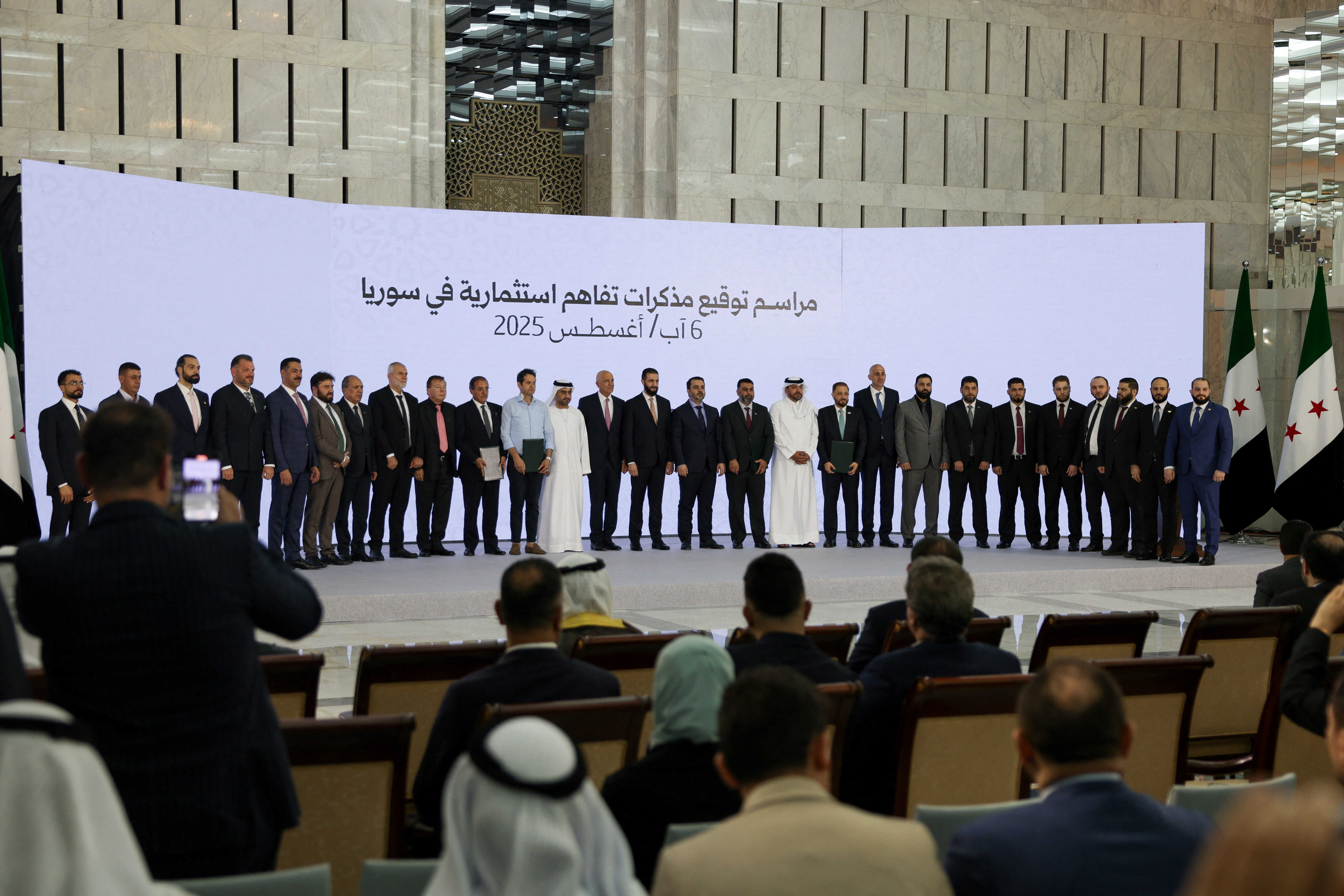 Syrian President Ahmed Al-Sharaa, Syrian Foreign Minister Asaad Hassan Al-Shibani and US special envoy for Syria Tom Barrack pose for a group photo during a signing ceremony of a memorandum of understanding for investment in Syria, in Damascus, Syria August 6, 2025. Reuters
