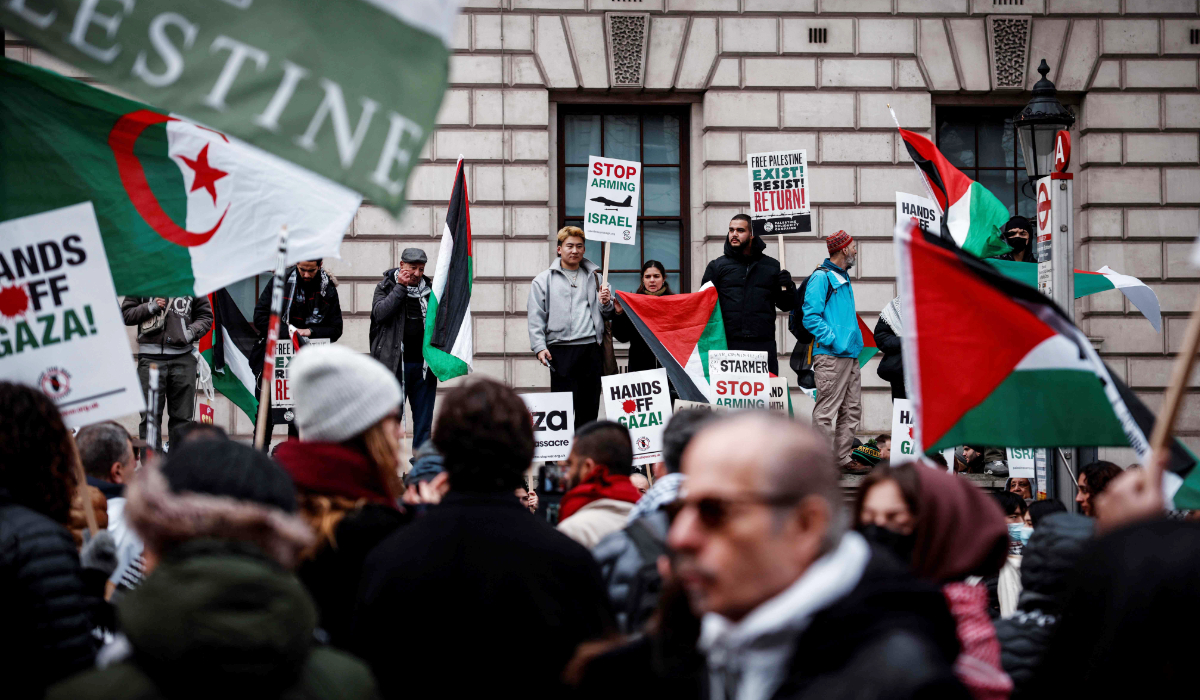 Protesters hold placards and wave Palestinian flags as they take part in a Pro-Palestinian march in central London, on February 15, 2025, organised by the Palestine Solidarity Campaign. (AFP)
