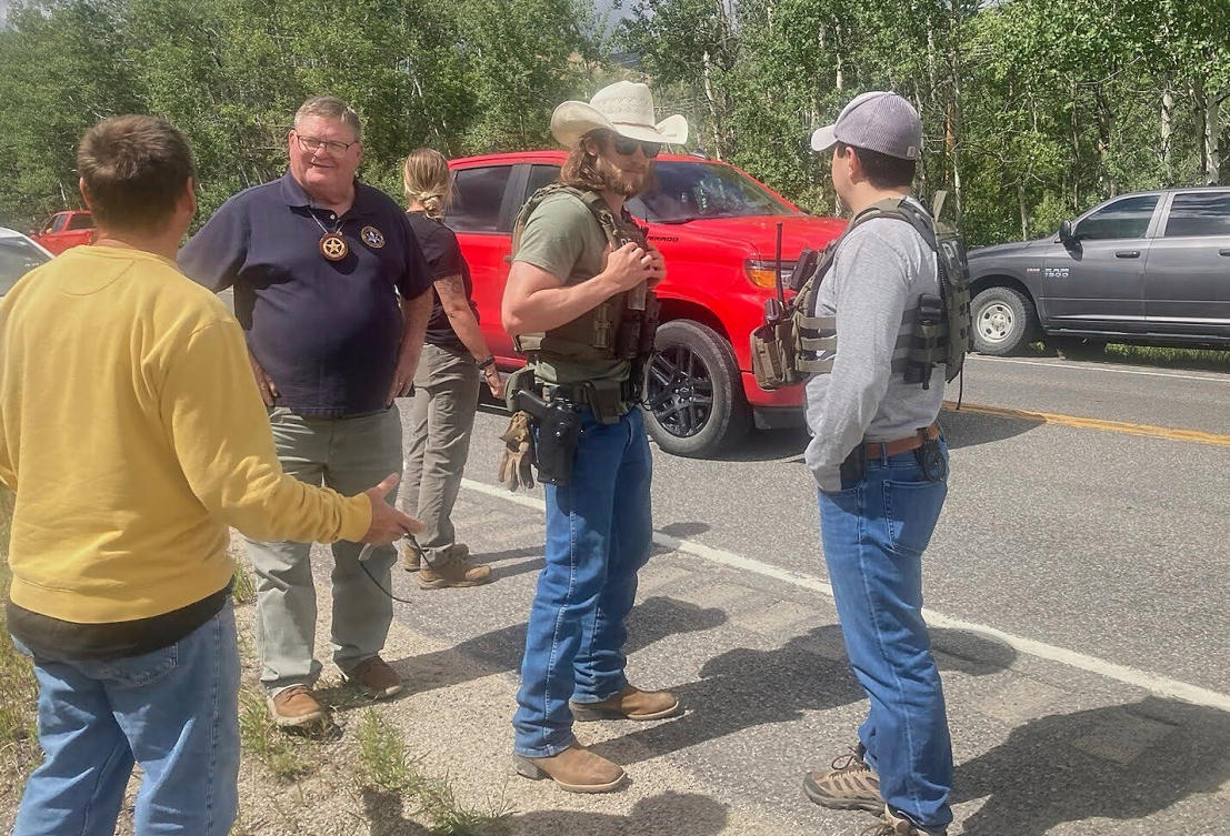 Law enforcement officers stand at the scene where Michael Brown, a suspect in a shooting at a Montana bar that left four people dead, was apprehended on Friday, Aug. 8, 2025. (The Montana Standard via AP)