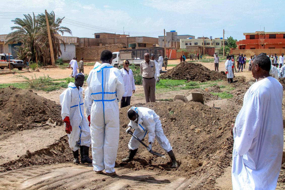 Members of the Sudanese Red Crescent and forensic experts exhume the remains of people from makeshift graves for reburial in the local cemetery in Khartoum's southern suburb of al-Azhari last week. (AFP)