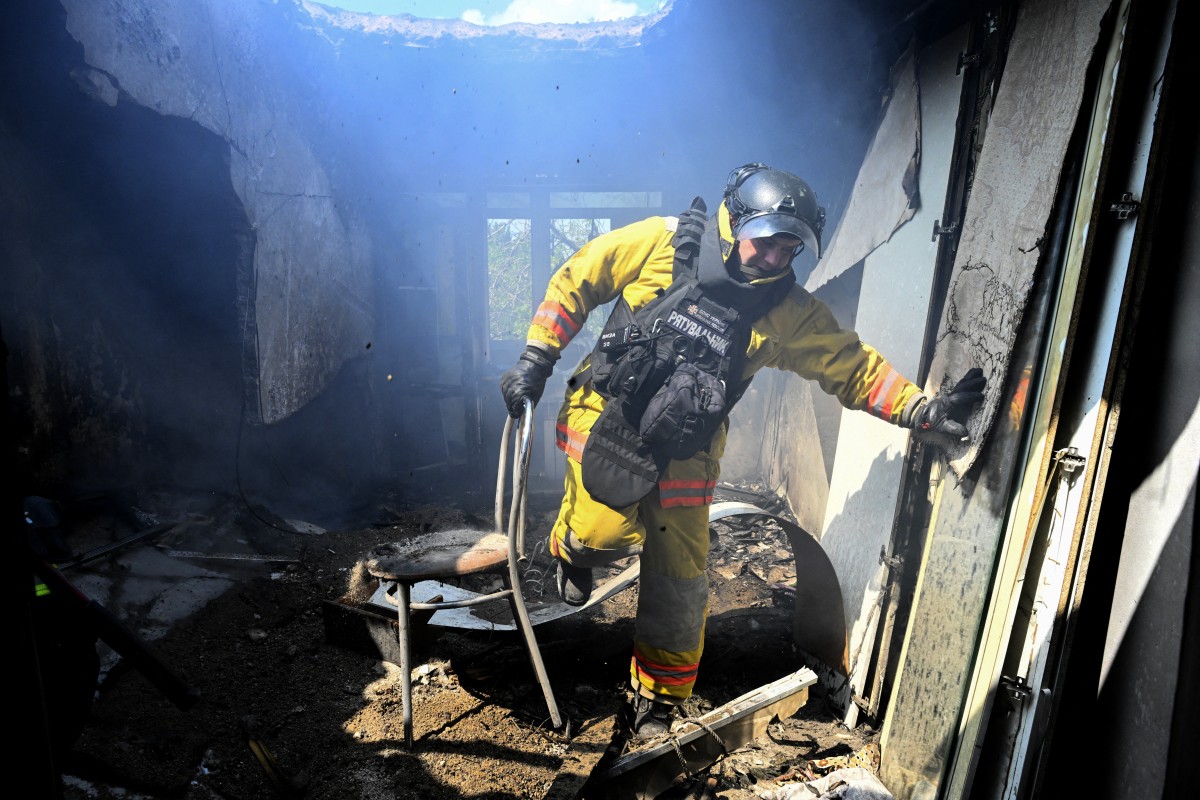 An Ukrainian firefighter extinguishes a fire in a destroyed apartment following a Russian drone strike in the town of Bilozerske, Donetsk region, August 10, 2025. (AFP)