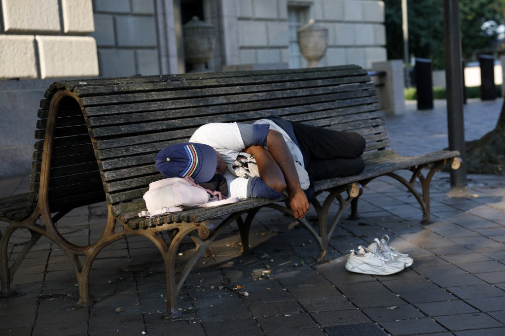 A person sleeps on a bench in Washington, DC, July 25, 2025. (AFP)