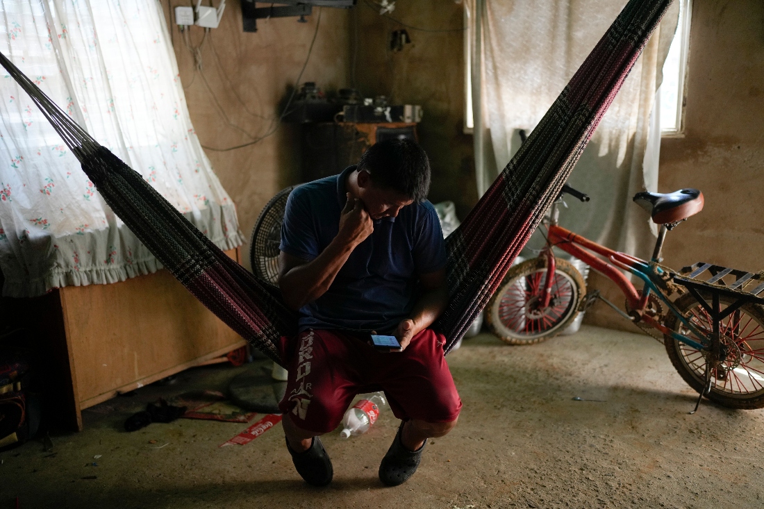 Jose Romero, who returned to Venezuela from Mexico with his wife and their five children after abandoning plans to reach the United States looks at his phone, in Maracaibo, Venezuela. (AP)