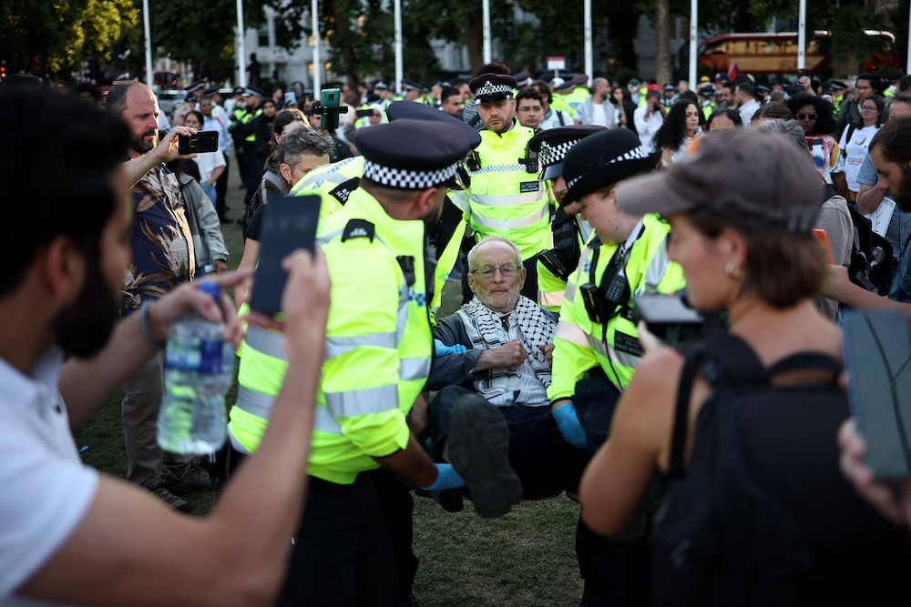 A protester is carried away by police officers in Parliament Square, central London, on Aug. 9, 2025. (AFP)