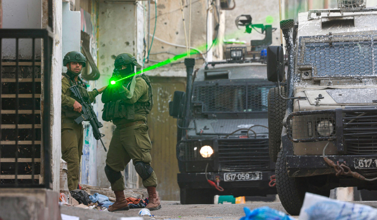 An Israeli soldier aims his weapon during a raid at the Balata refugee camp east of Nablus city in the occupied West Bank on August 11, 2025. (AFP)