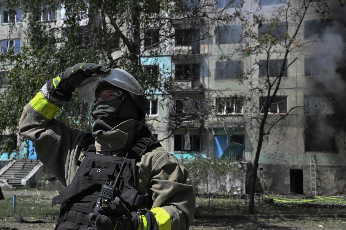 A Ukrainian firefighter checks the sky for drones at the site of a Russian drone strike in Bilozerske, Donetsk region on Aug. 10, 2025. (AFP)
