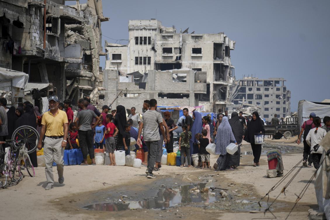 In the summer heat, Palestinians line up to collect water from a distribution point in Gaza City, Tuesday, Aug. 12, 2025. (AP)