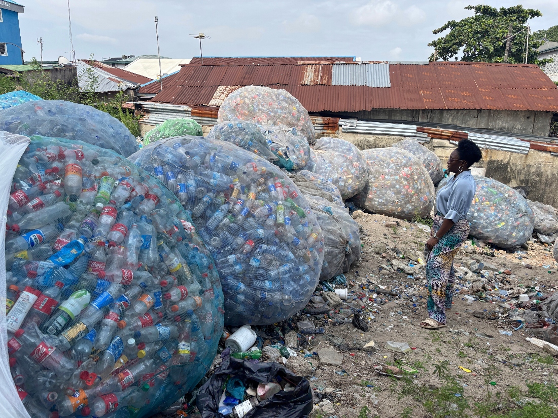 Omoh Alokwe, co-founder of Street Waste Company, stands in front of plastic waste in Lagos, Nigeria. (AP)