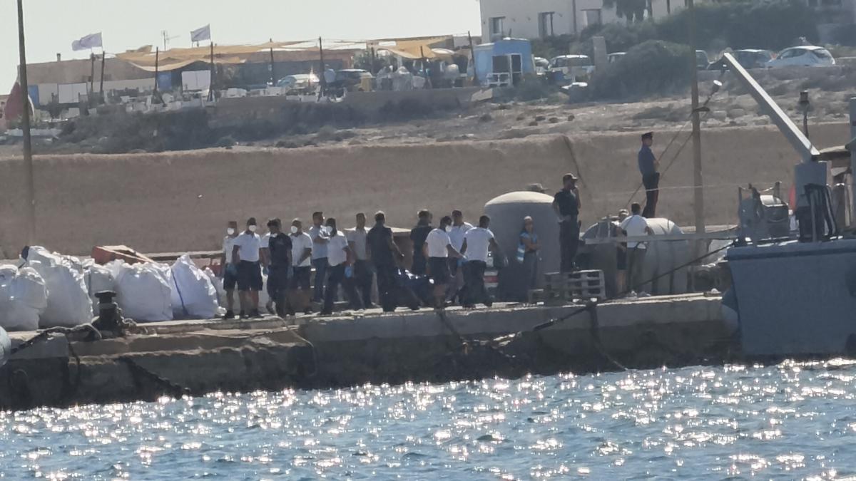 Italian Coast Guards carry a body bag on the dock of Lampedusa harbor, Wednesday, Aug. 13, 2025, after a boat carrying nearly 100 migrants capsized off the Italian island. (AP Photo)