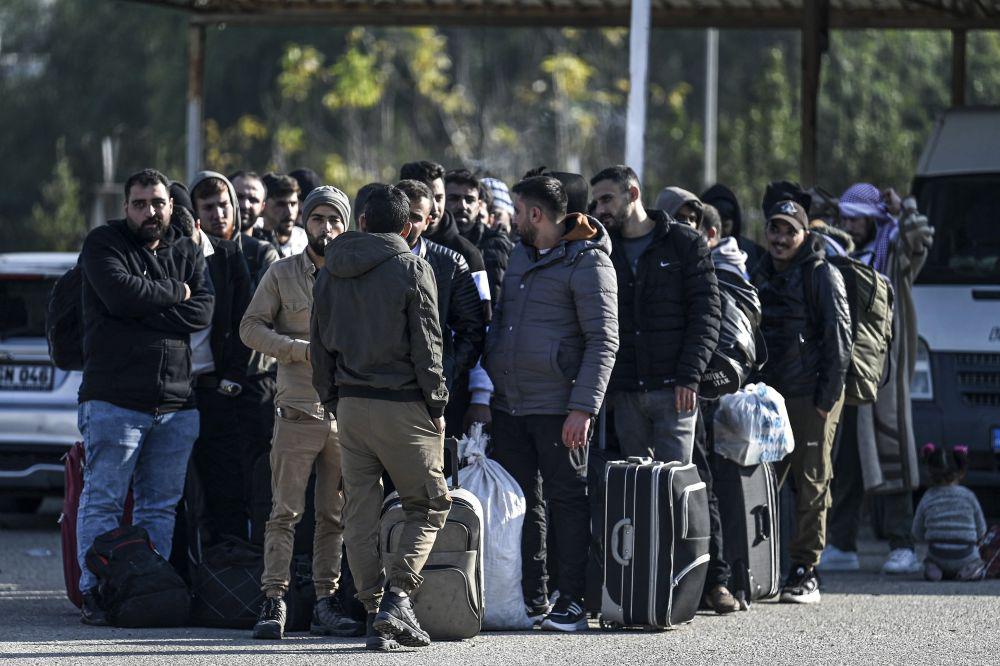 Syrian refugees, resident in Turkiye, wait with their belongings at Cilvegozu border crossing, Reyhanli district, Hatay province, before entering Syria, Dec. 9, 2024. (AFP)