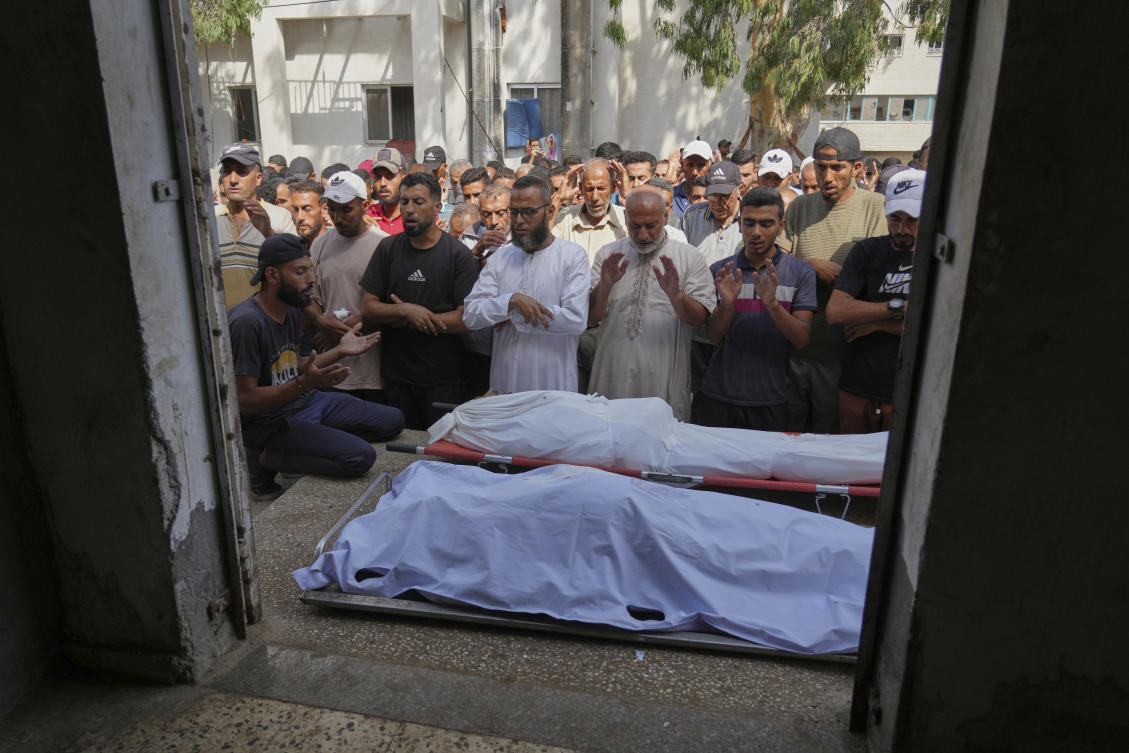 Palestinians pray over the bodies of people who, according to the families, were killed in an Israeli army airstrike on a school that has been used as a shelter, during their funeral at Shifa Hospital in Gaza City, Saturday, Aug. 16, 2025. (AP)