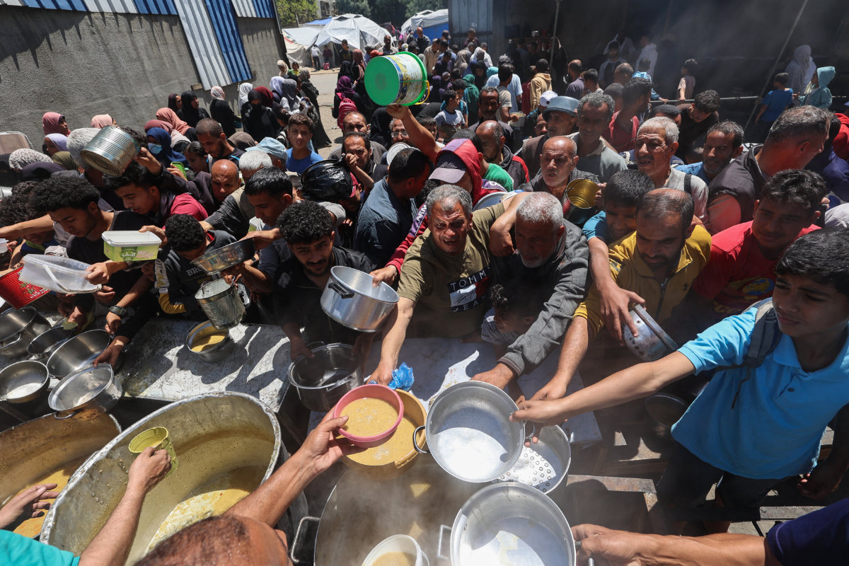Palestinians queue for a hot meal at a charity kitchen run by the United Nation's World Food Programme (WFP) at the Nuseirat refugee camp in the central Gaza Strip on April 26, 2025.