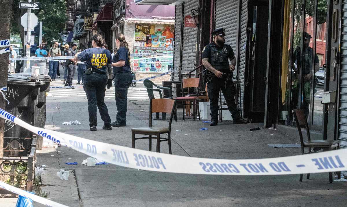 Members of the New York City police department (NYPD) investigate a shooting scene at Taste of the City lounge on August 17, 2025 in the Crown Heights neighborhood of the Brooklyn borough in New York City. (AFP)