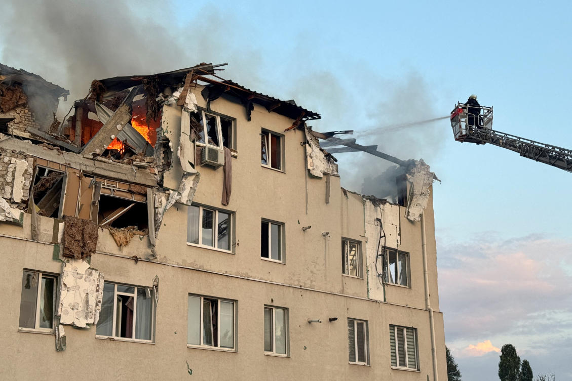 A firefighter works at the site of an apartment building hit by a Russian drone strike, amid Russia's attack on Ukraine, in Kharkiv, Ukraine August 18, 2025. (REUTERS/)