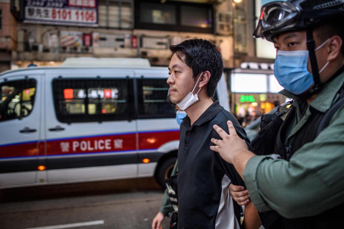 Above, pro-democracy legislator Ted Hui is detained by police during a rally in Hong Kong on June 12, 2020. Hui has been granted asylum in Australia, he said in a social media post. (AFP)