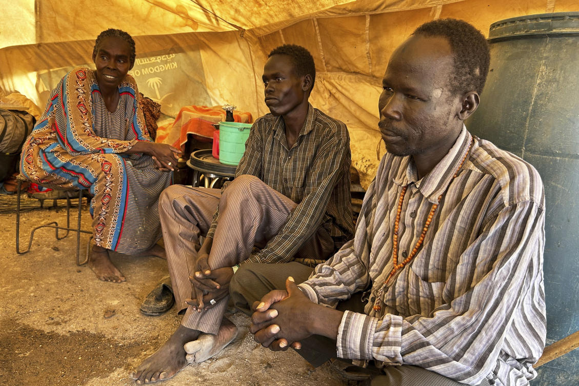 Daud Mahmoud Abdullah, who says he spent six months in prison after being accused of cooperating with the Rapid Support Forces, sits with his wife and brother, whom he was reunited with at the Renk transit center, South Sudan on Aug 9, 2025. (AP)