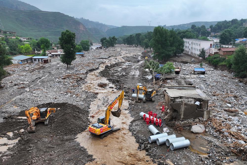 Workers carry out repairs a day after a flash flood in Yuzhong county, in China’s northwest Gansu province on Aug. 9, 2025. Heavy rainfall and severe floods that meteorologists link to climate change pose major challenges for authorities. (AFP)