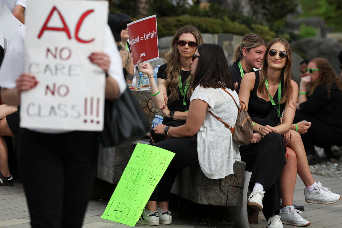Striking Air Canada flight attendants sit on a picket line as they defy a back to work order at Vancouver International Airport in Richmond, British Columbia on Aug. 18, 2025. (Reuters)