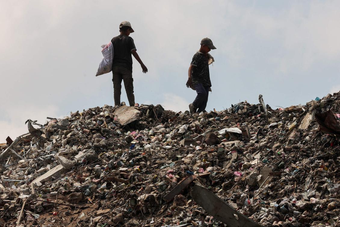 Palestinians search for things to rescue at a garbage waste dump in Gaza City on August 18, 2025. (AFP)