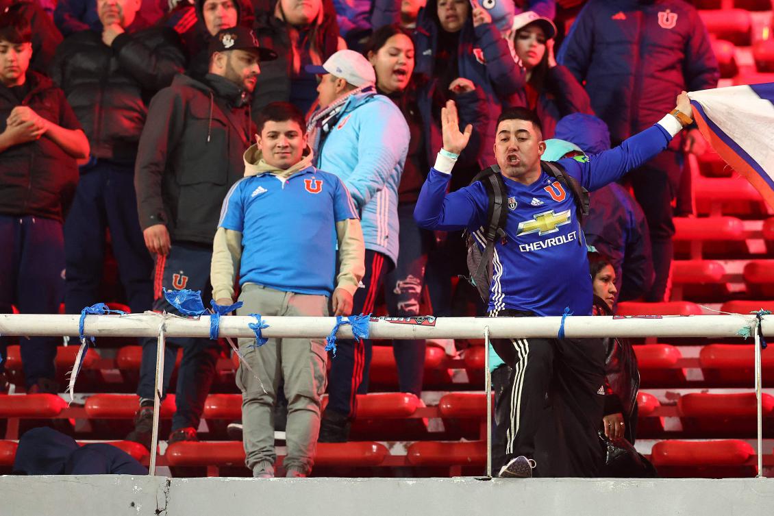 A fan of Universidad de Chile shouts from the stands during the Copa Sudamericana round of 16 second leg football match between Argentina's Independiente and Chile's Universidad de Chile at the Libertadores de America stadium in Avellaneda, Buenos Aires province, Argentina on August 20, 2025. (Photo by Alejandro PAGNI / AFP)