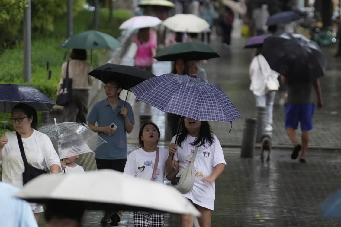 People walk with umbrellas during the rain in Beijing, China, Tuesday, Aug. 19, 2025. (AP)