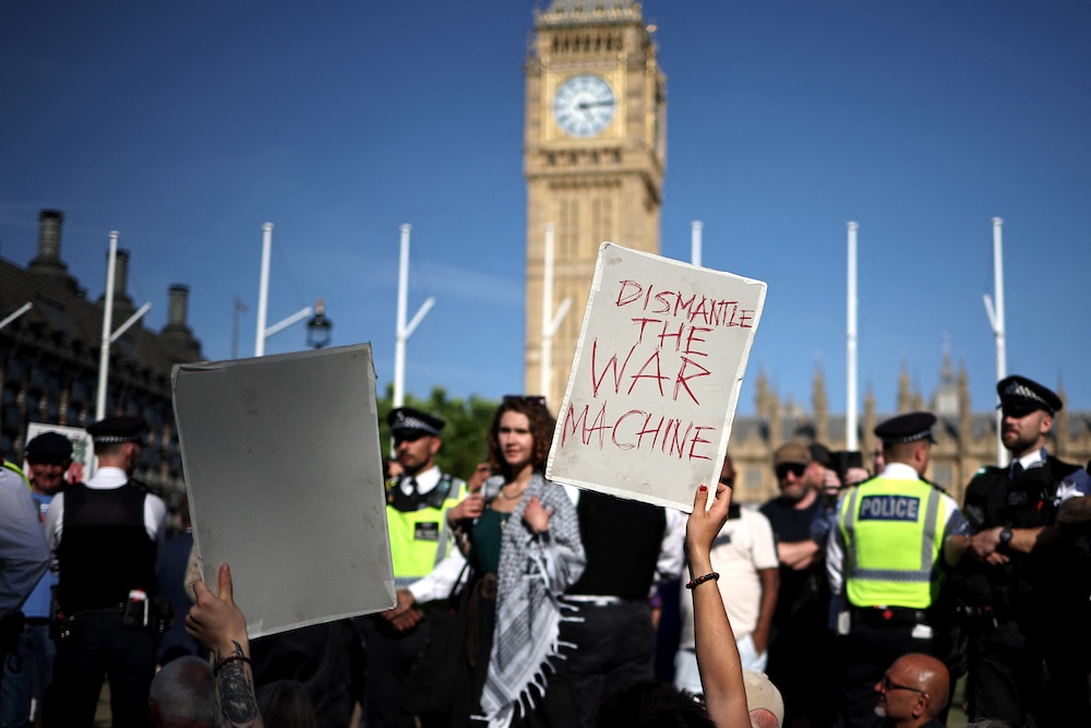 Protesters hold placards in support of Palestine Action during a demonstration in Parliament Square, central London on Aug. 9, 2025. (AFP)