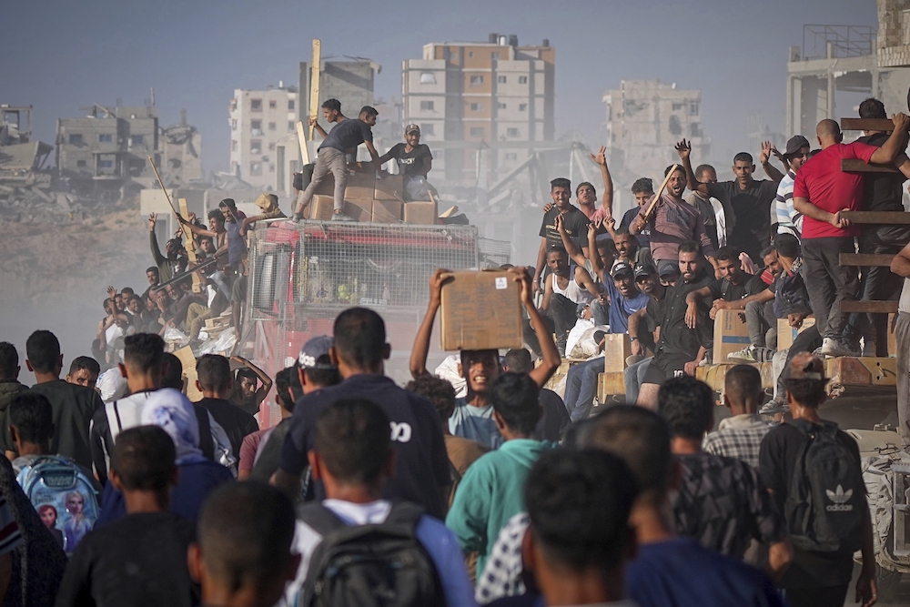 Palestinians ride on a truck loaded with food and humanitarian aid from the World Food Program, after it arrived in the northern Gaza Strip, June 16, 2025. (AP/File Photo)
