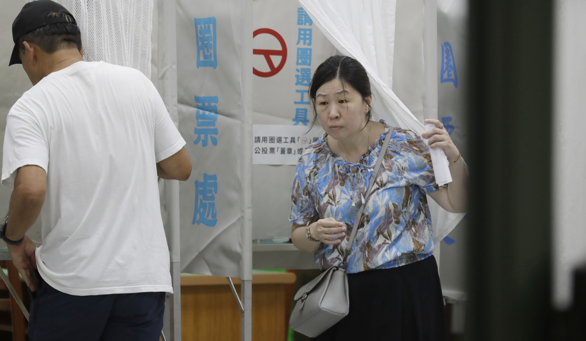 A woman emerges from a voting booth at a polling station in Taipei, Taiwan, Saturday, Aug. 23, 2025, during the vote which includes a referendum on restarting the Maanshan nuclear power plant. (AP)