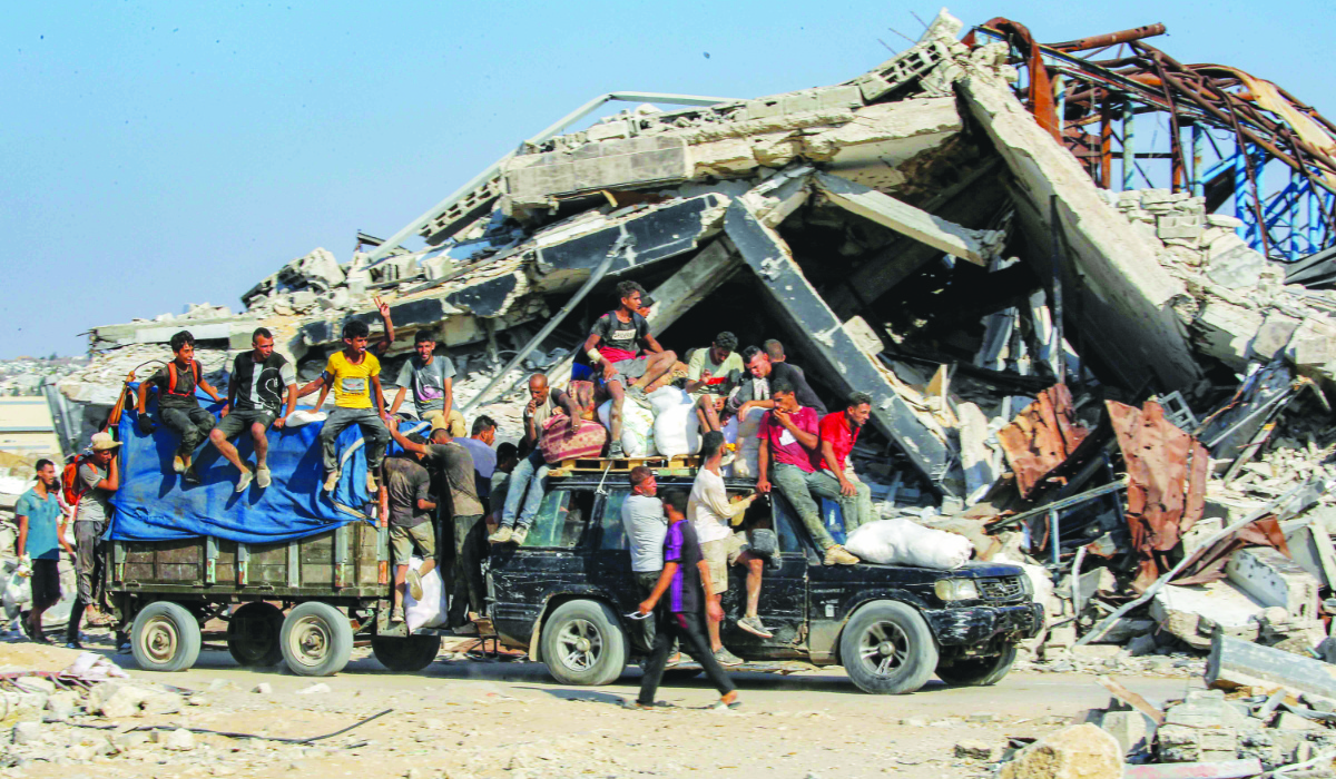 Palestinians travel with bags of humanitarian aid received at a distribution center run by the Gaza Humanitarian Foundation in the central Gaza Strip. (AFP)