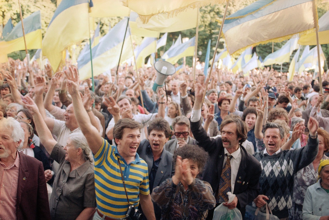 A photo dated 1991 shows people waving Ukrainian national flags as they gather outside the parliament building during a pro independence rally in Kyiv, Ukraine. (AP)