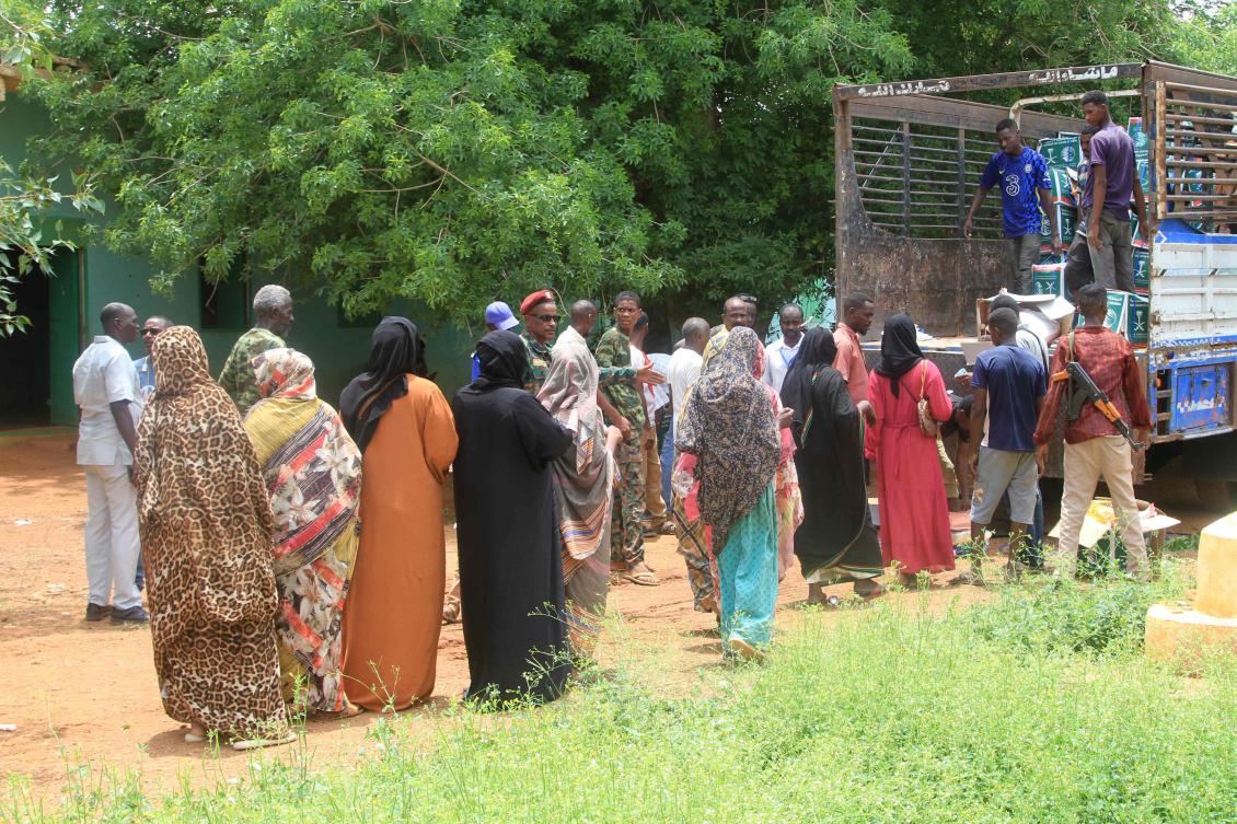Sudanese, who have recently returned from being displaced, queue to receive humanitarian aid in Ombada, west of Omdurman on August 24, 2025. (AFP)
