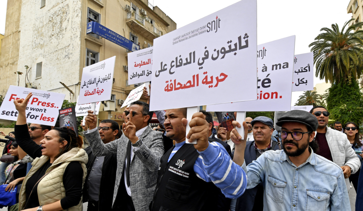 Tunisian journalists hold signs during a protest demanding press freedom outside the National Syndicate of Tunisian Journalists (SNJT) in Tunis on May 5, 2022. (AFP)