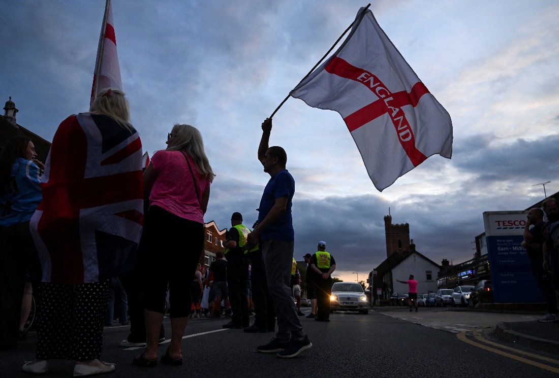 A man waves a flag with 'England' written on it during an anti immigration demonstration. (Reuters)