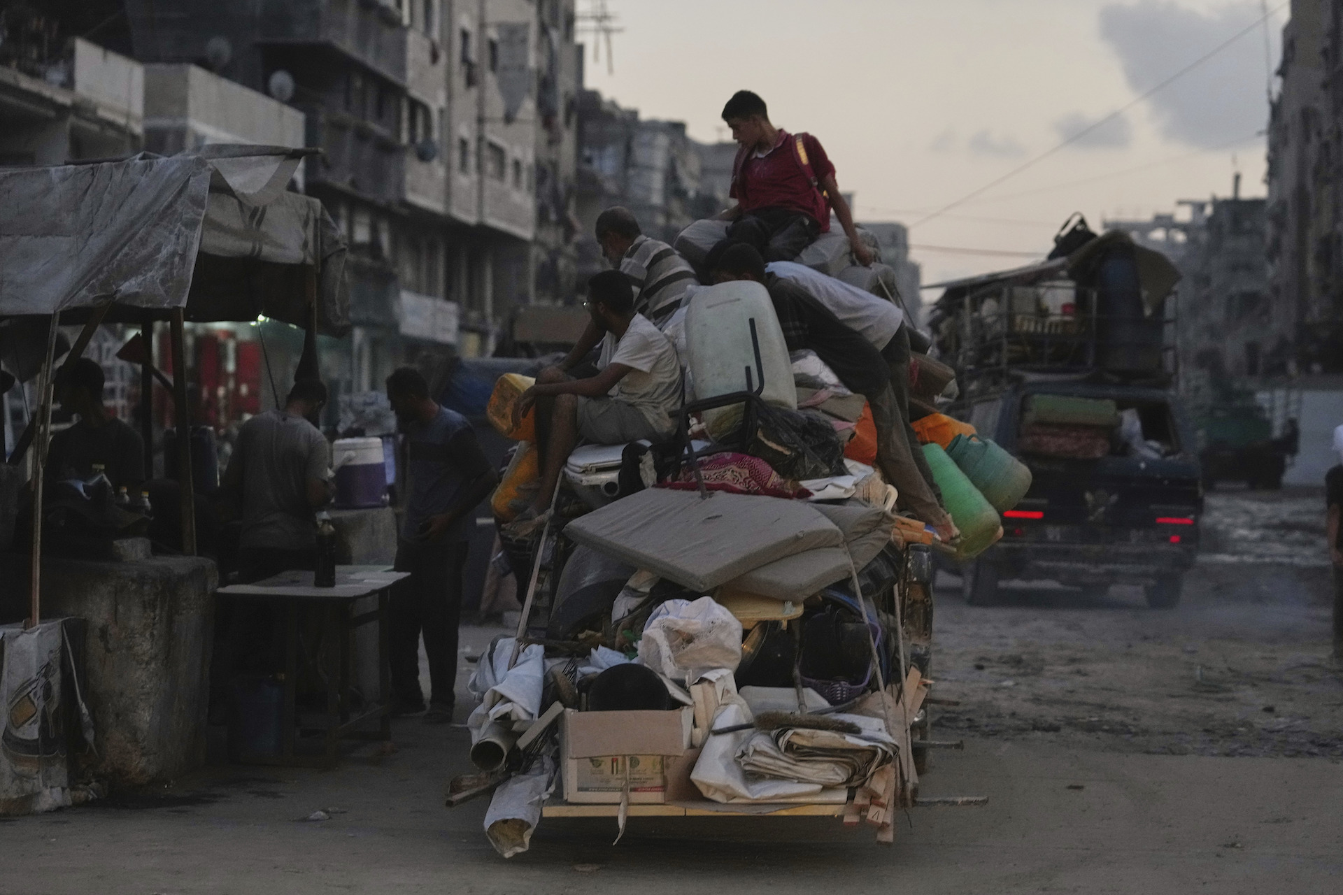 Displaced Palestinians fleeing Jabaliya move with their belongings on a street in Gaza City, Tuesday, Aug. 26, 2025. (AP Photo/Jehad Alshrafi)